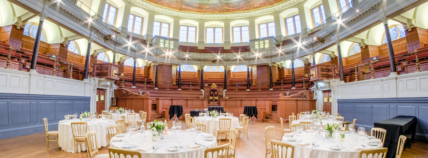 Photo of Sheldonian Theatre with tables and chairs set up for a wedding reception