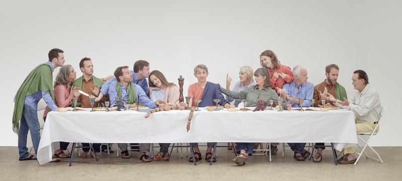 Photo of people sitting on a long table engaging in conversation, replicating Leonardo Da Vinci's 'The Last Supper' paining