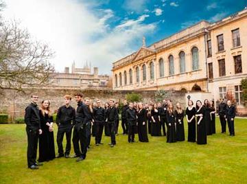 Photo of Queen's College Choir standing in the grounds of the college