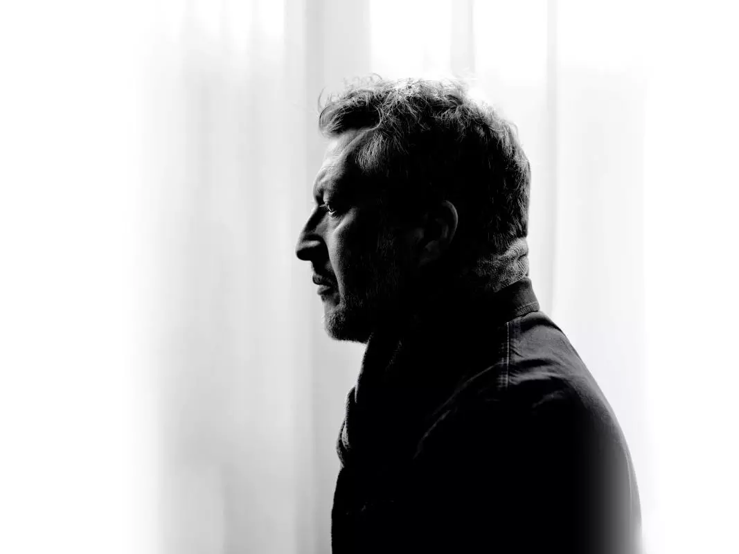 Man in coat staring off to left hand side in black and white