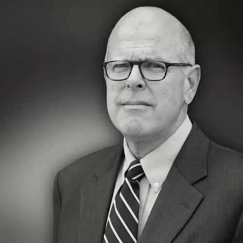 Bald man in glasses looking at the camera in black and white