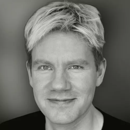 Blonde man staring at the camera in black and white